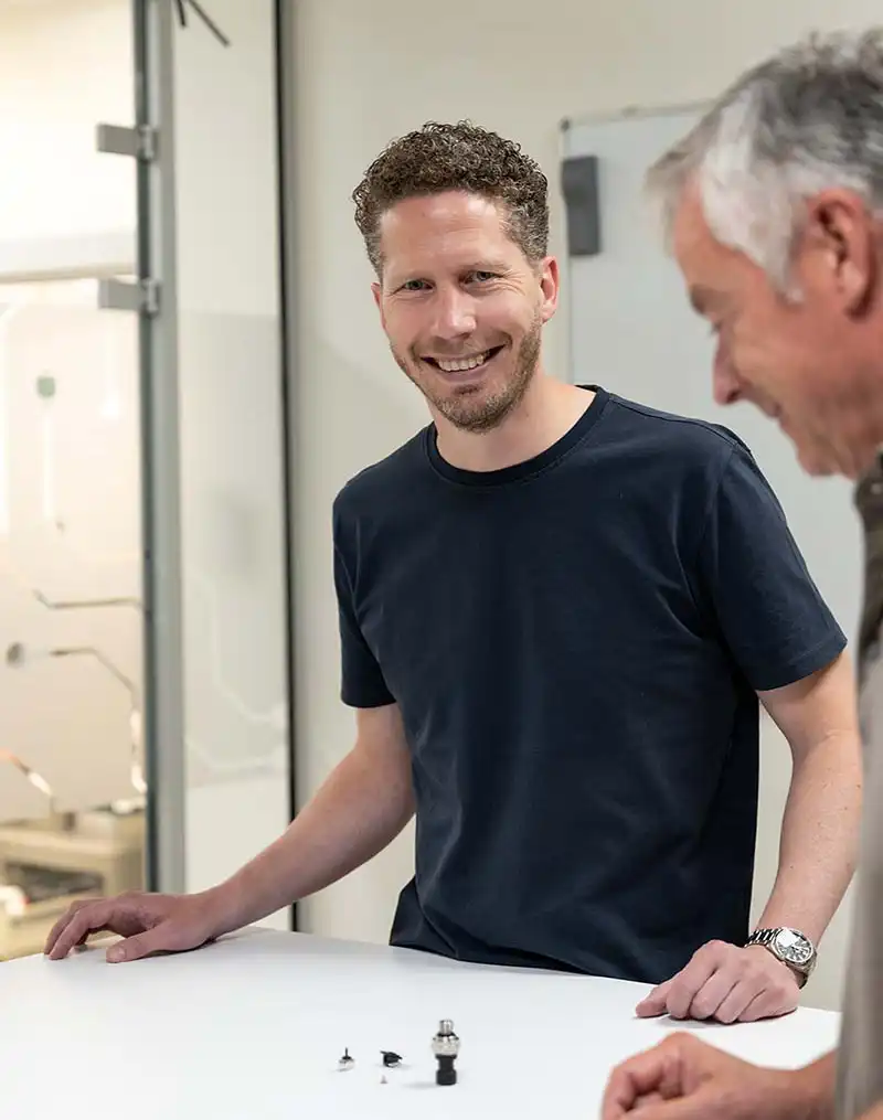 Directeur van Teleson in gesprek met collega over sensoren en machineveiligheid.